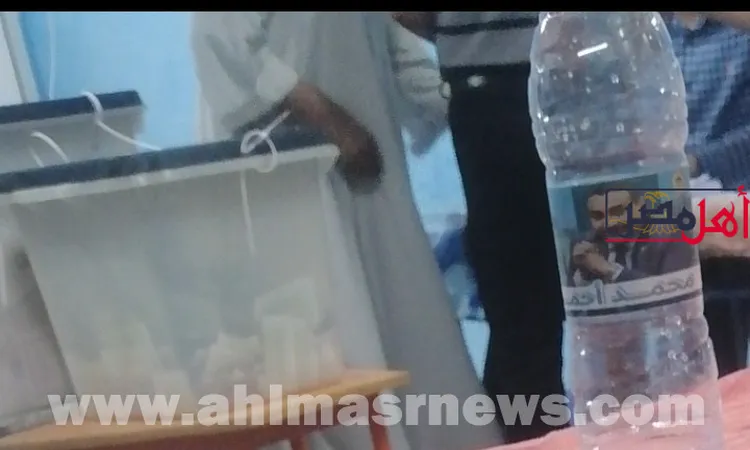 زجاجات المياه المعدنية تحمل صورة رمز مرشح بدائرة البندر في قنا